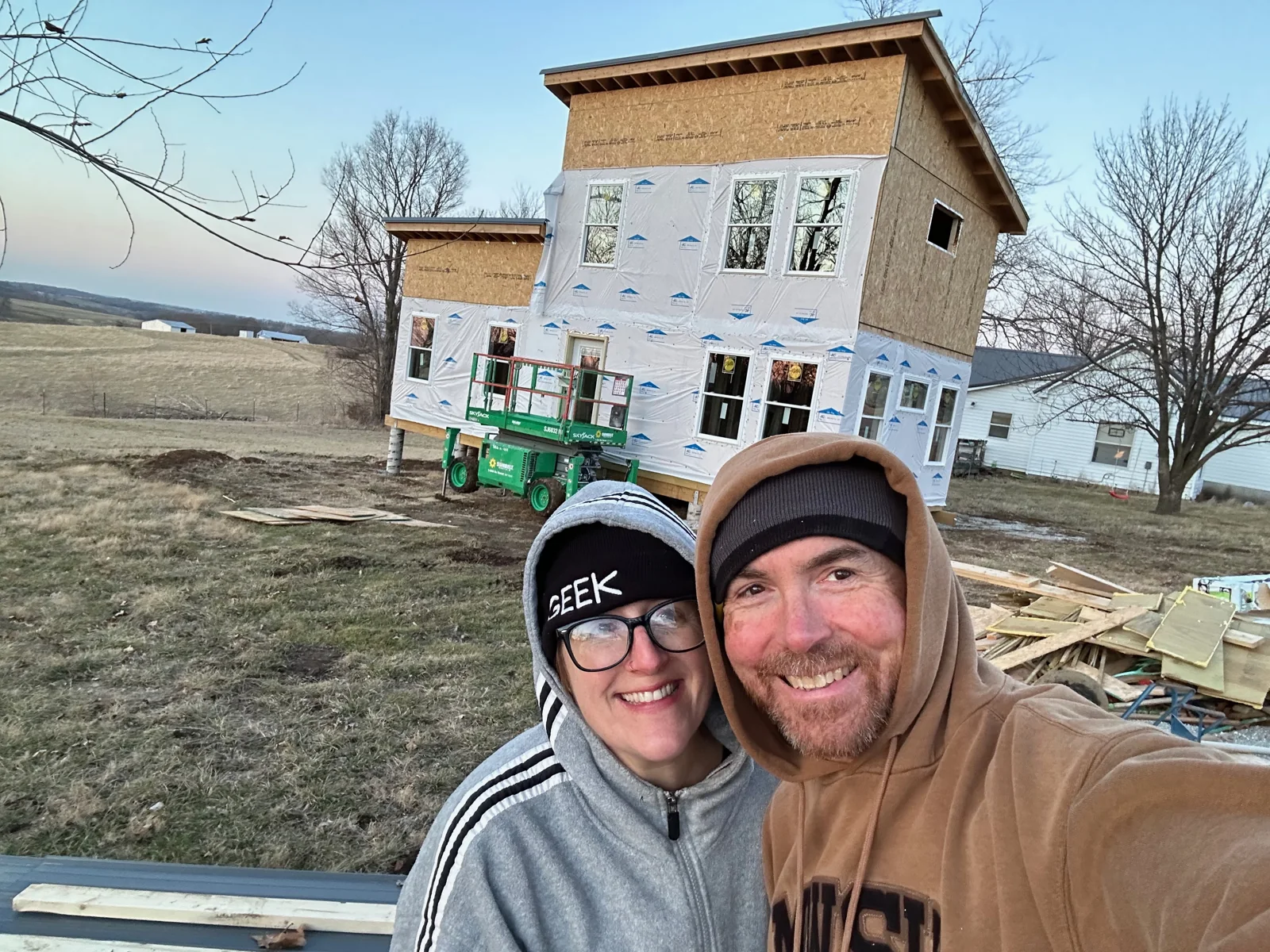 Brian and Calleen bundled up in front of the wrapped house.