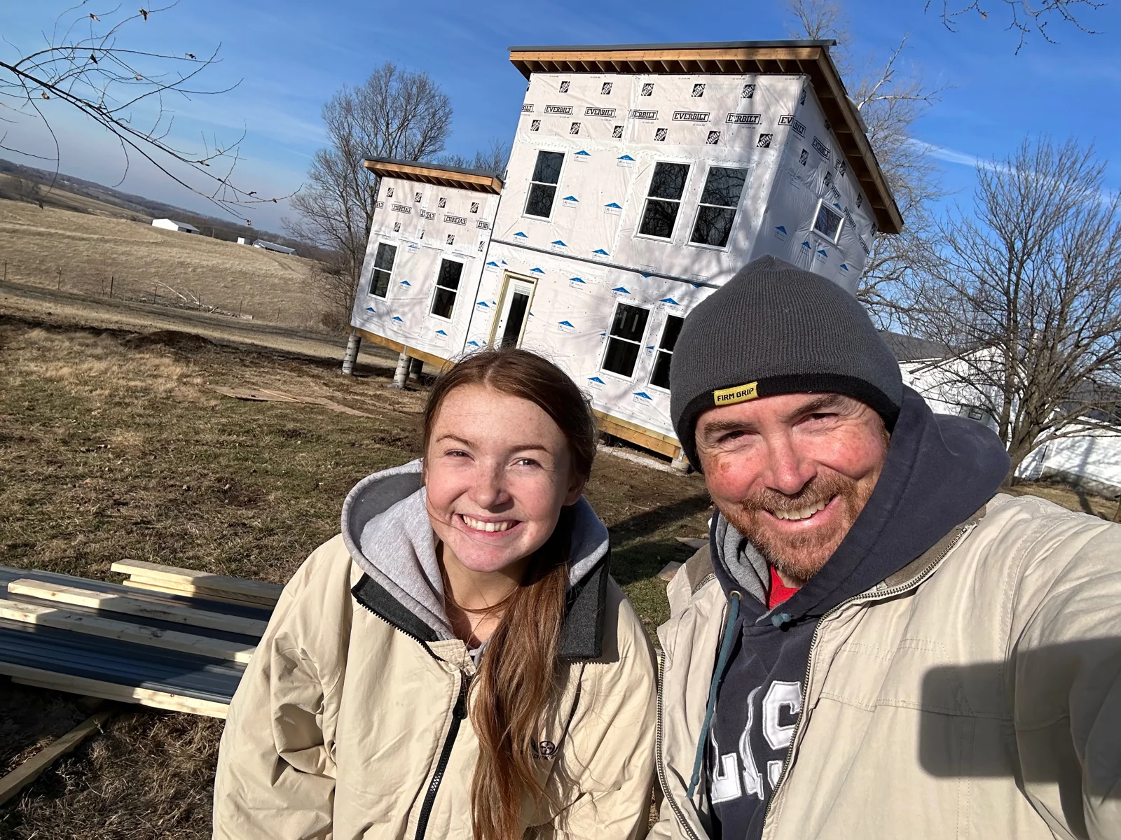 Brian and Sam in front of the wrapped house.