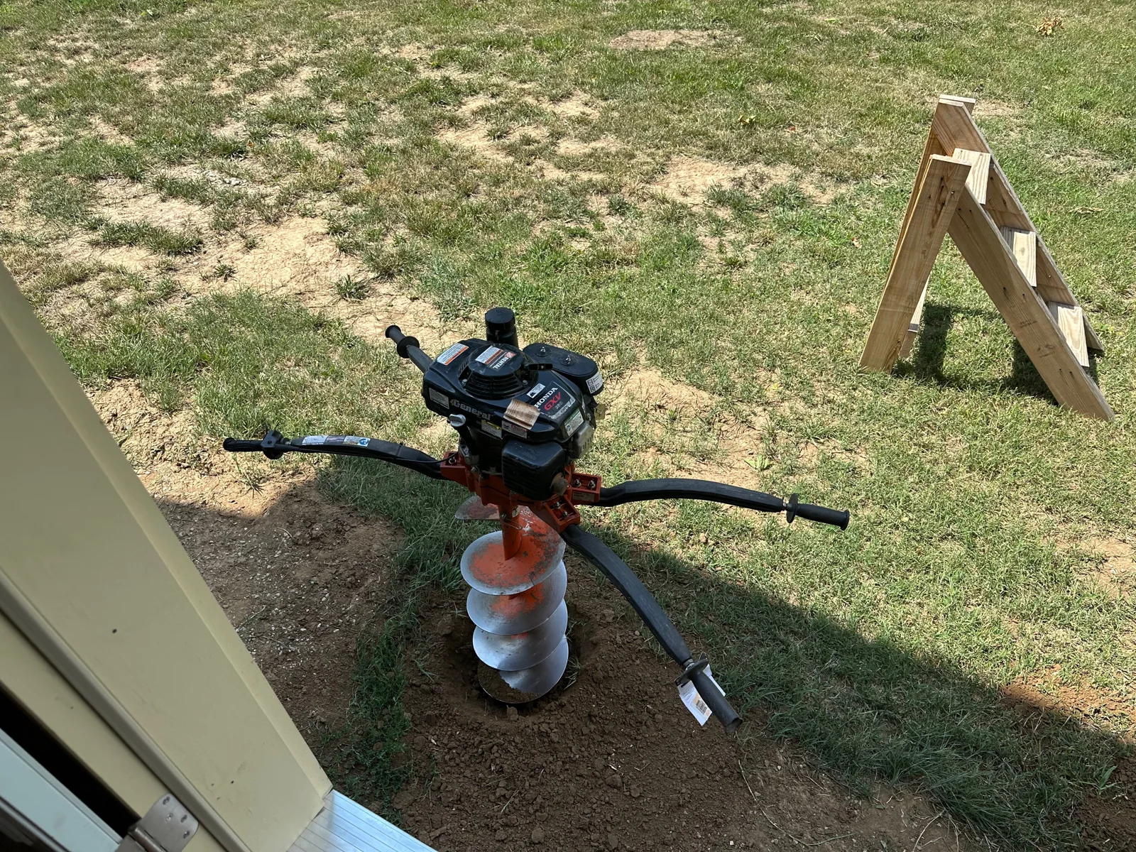 Deck post work underway with an auger at the site.