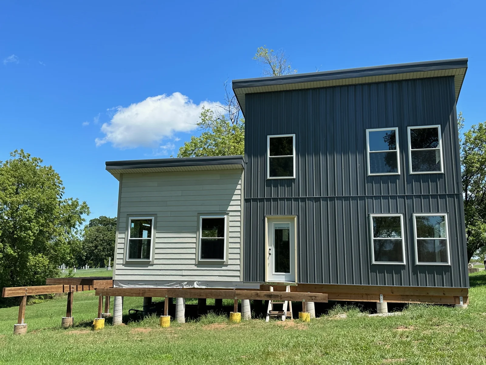 Katy Manor with siding installed, windows in place, and early deck framing at the front.