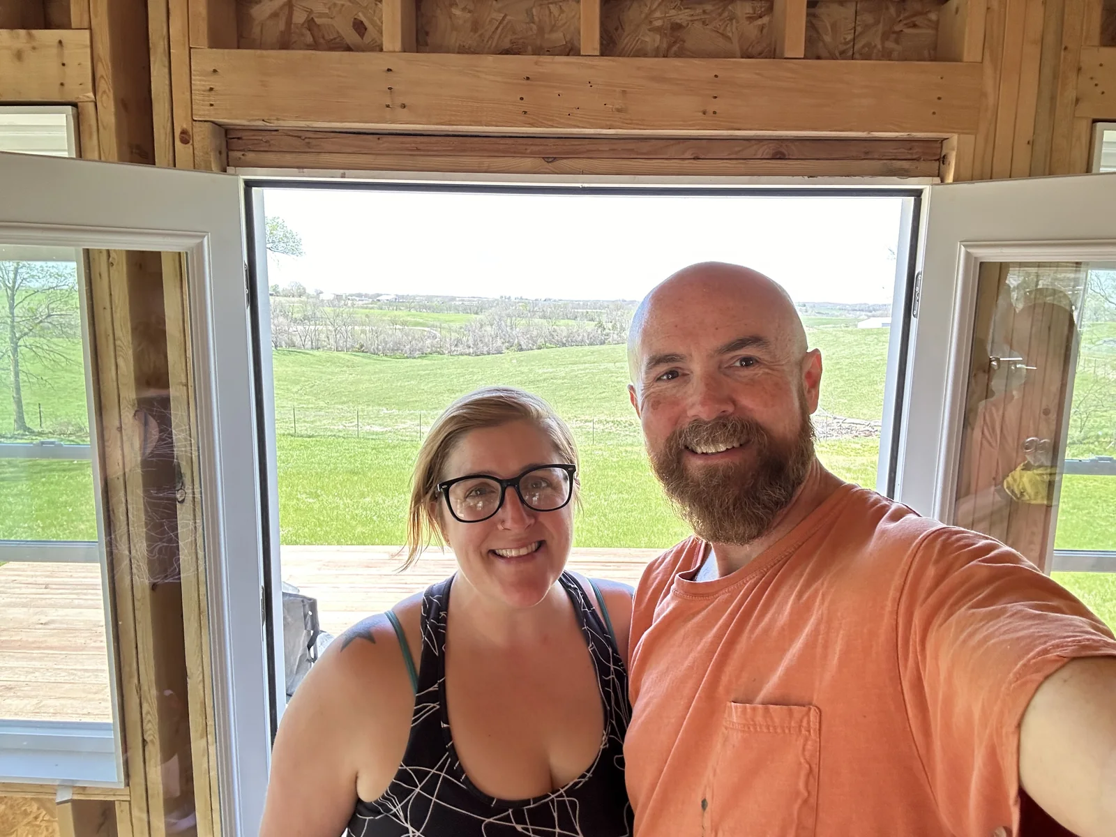 Brian and Calleen standing inside Katy Manor by open French doors.