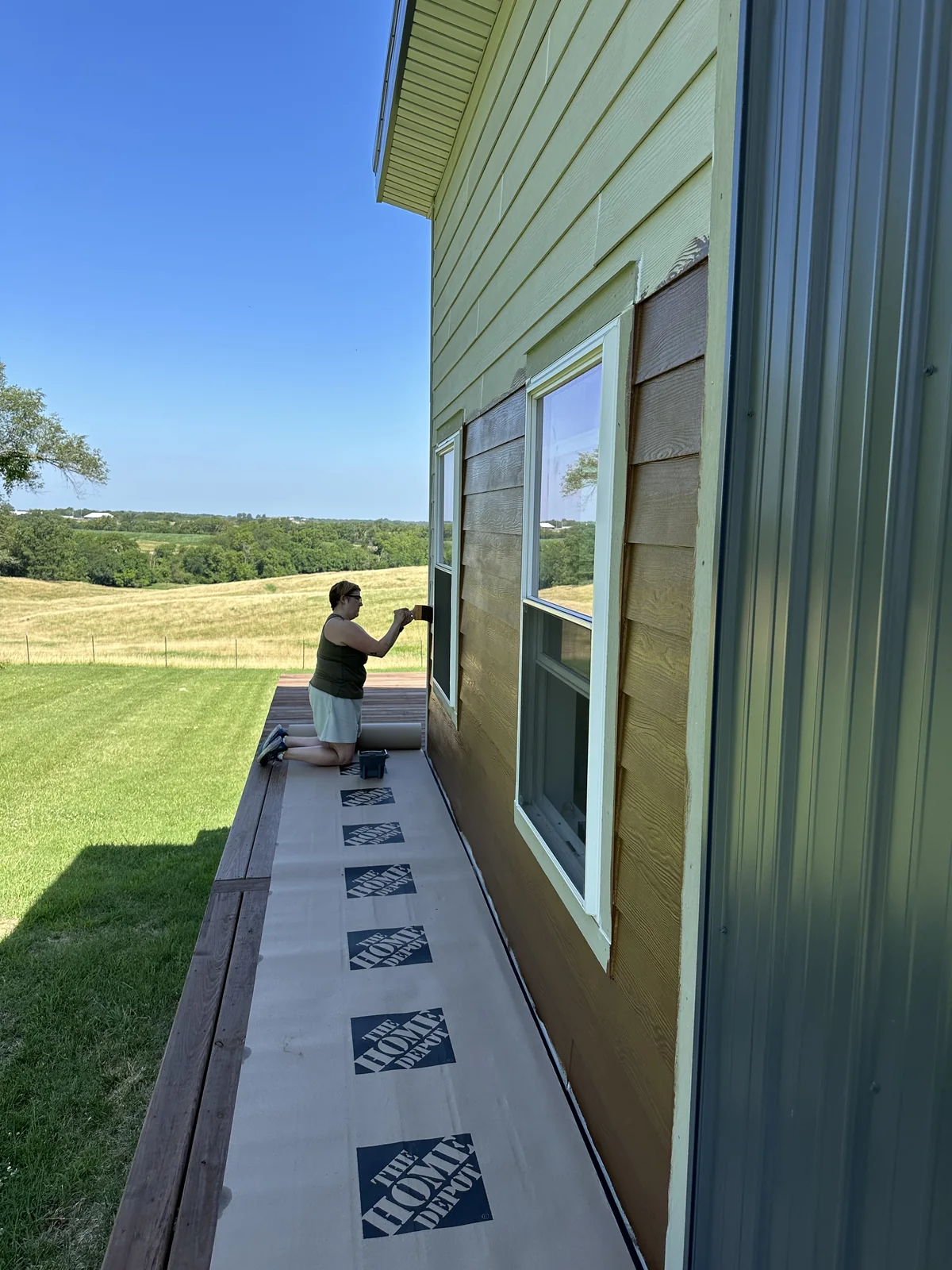 Painting the fiber cement siding from the deck.
