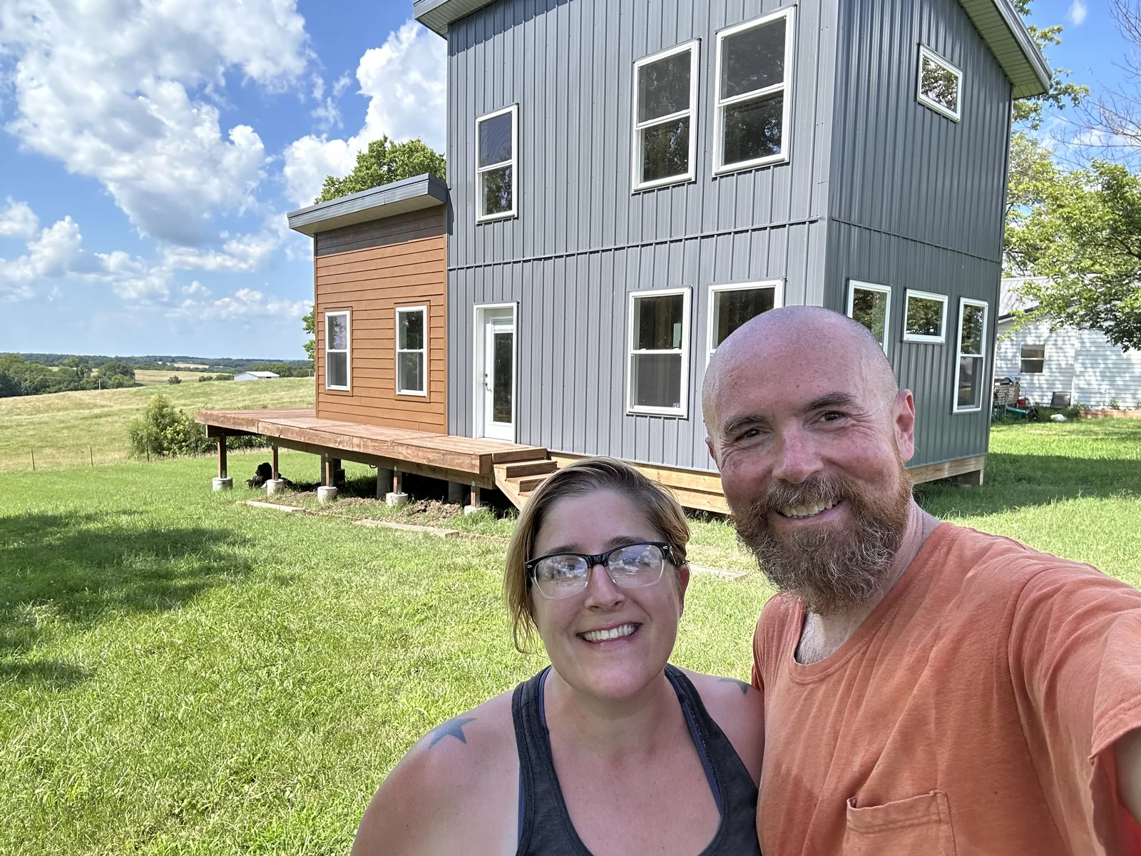 Brian and Calleen in front of Katy Manor with siding, paint, windows, and deck visible.